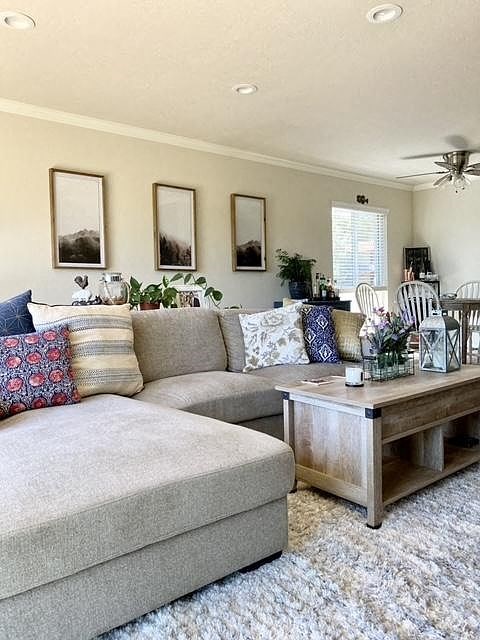 A living room with a grey couch, a wooden coffee table, and a ceiling fan.