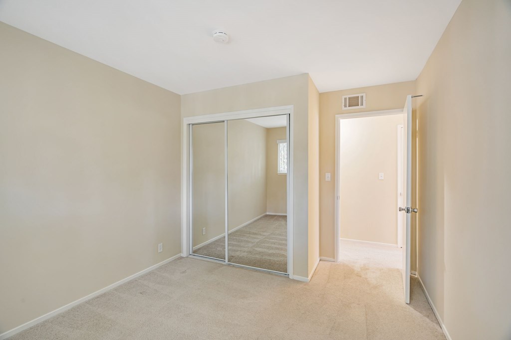 A room with a carpeted floor and a sliding glass door.