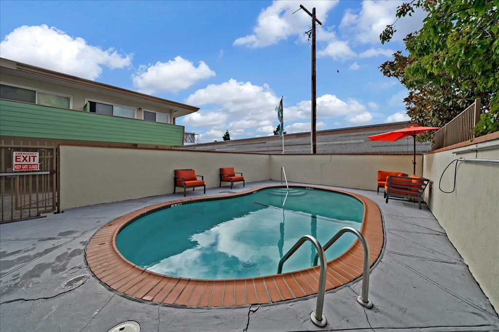 A small pool with a red tile border and a metal ladder.