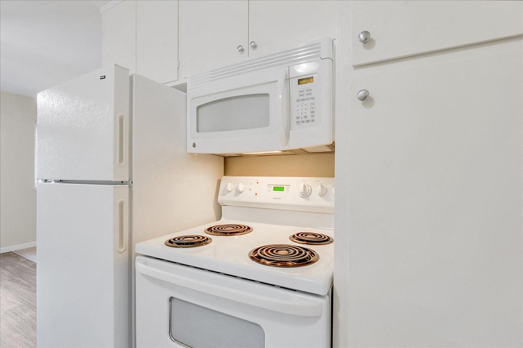 a kitchen with white appliances and a white refrigerator