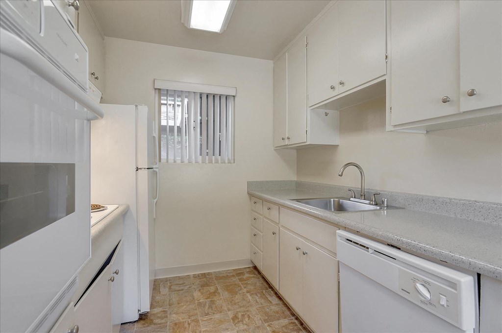 A kitchen with white appliances and cabinets.