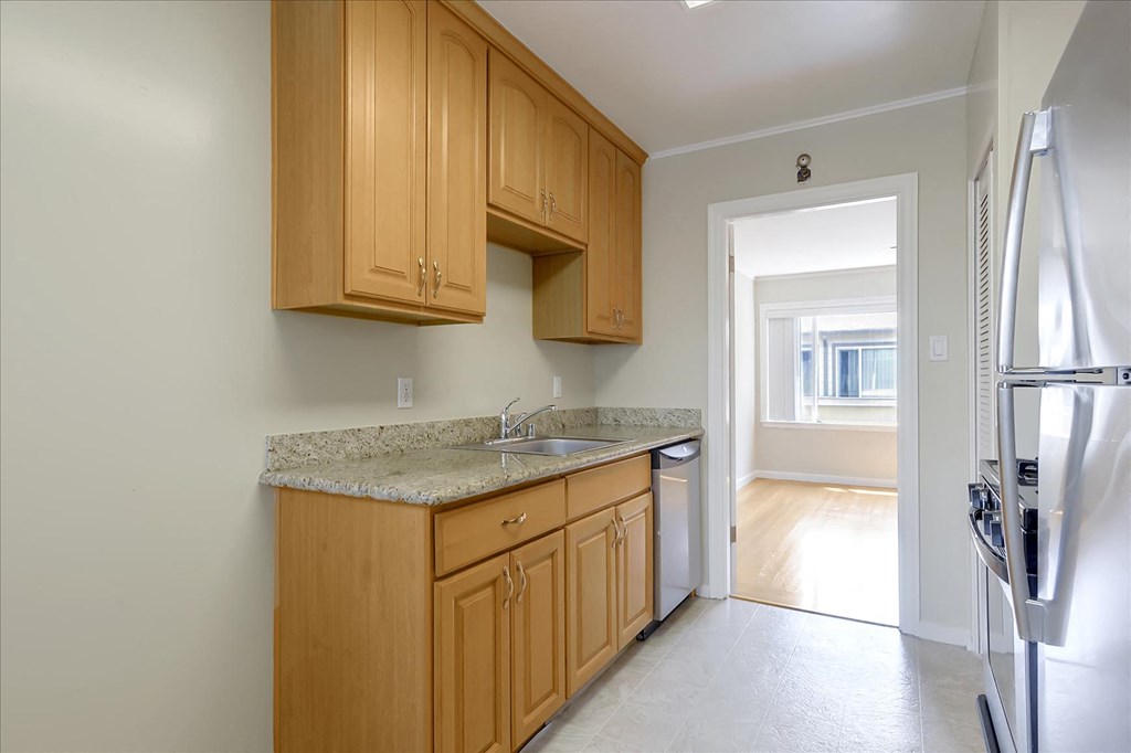 A kitchen with wooden cabinets and a granite countertop.