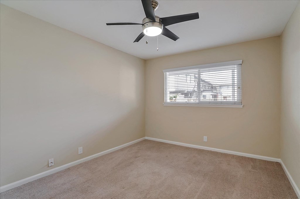 a bedroom with a ceiling fan and a window