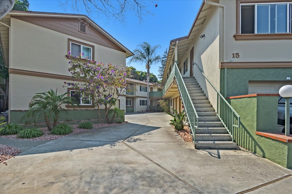 a sidewalk in front of two buildings with stairs