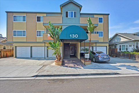 front of a condo building with a car parked in the driveway
