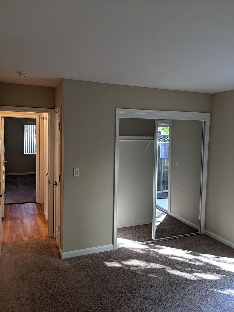 A room with a carpeted floor and a white door.