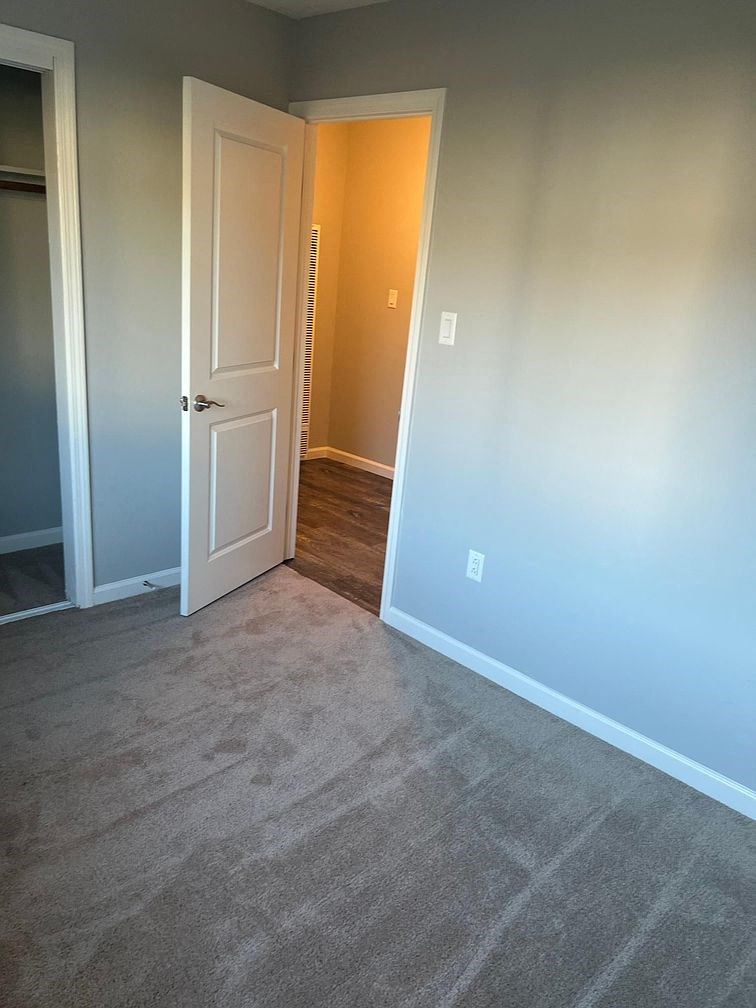 a room with a door and a carpeted floor