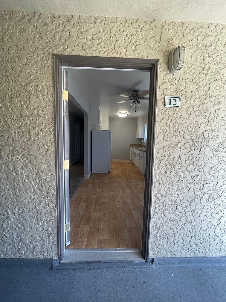 a door is open to a room with a refrigerator