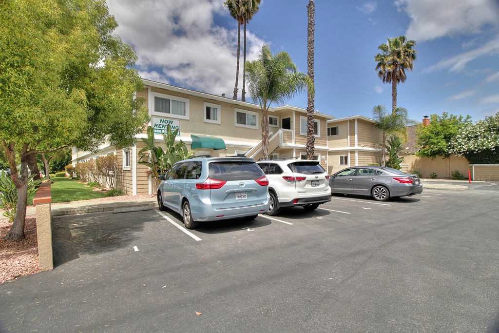 three cars parked in a parking lot in front of a building