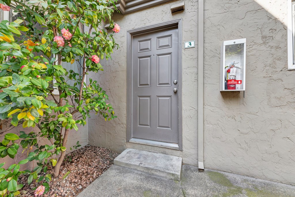 A grey door is closed with a grey mat in front of it.