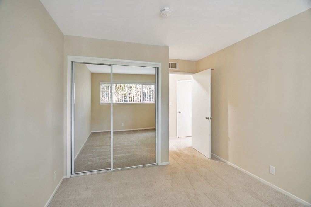 A room with a sliding glass door leading to a balcony.