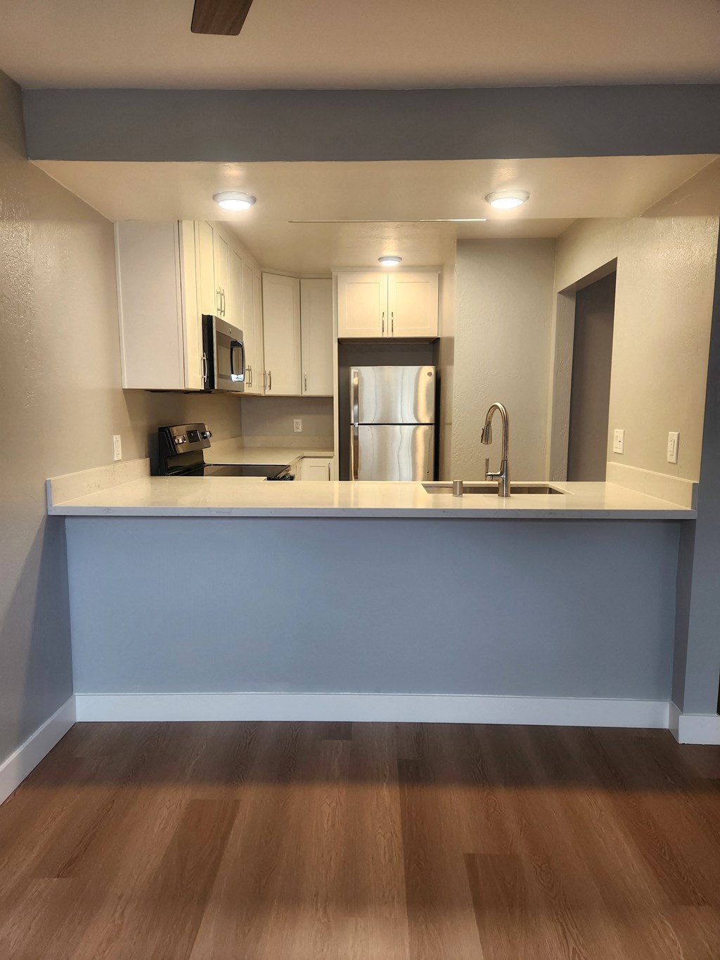 an empty kitchen with a counter top and a sink