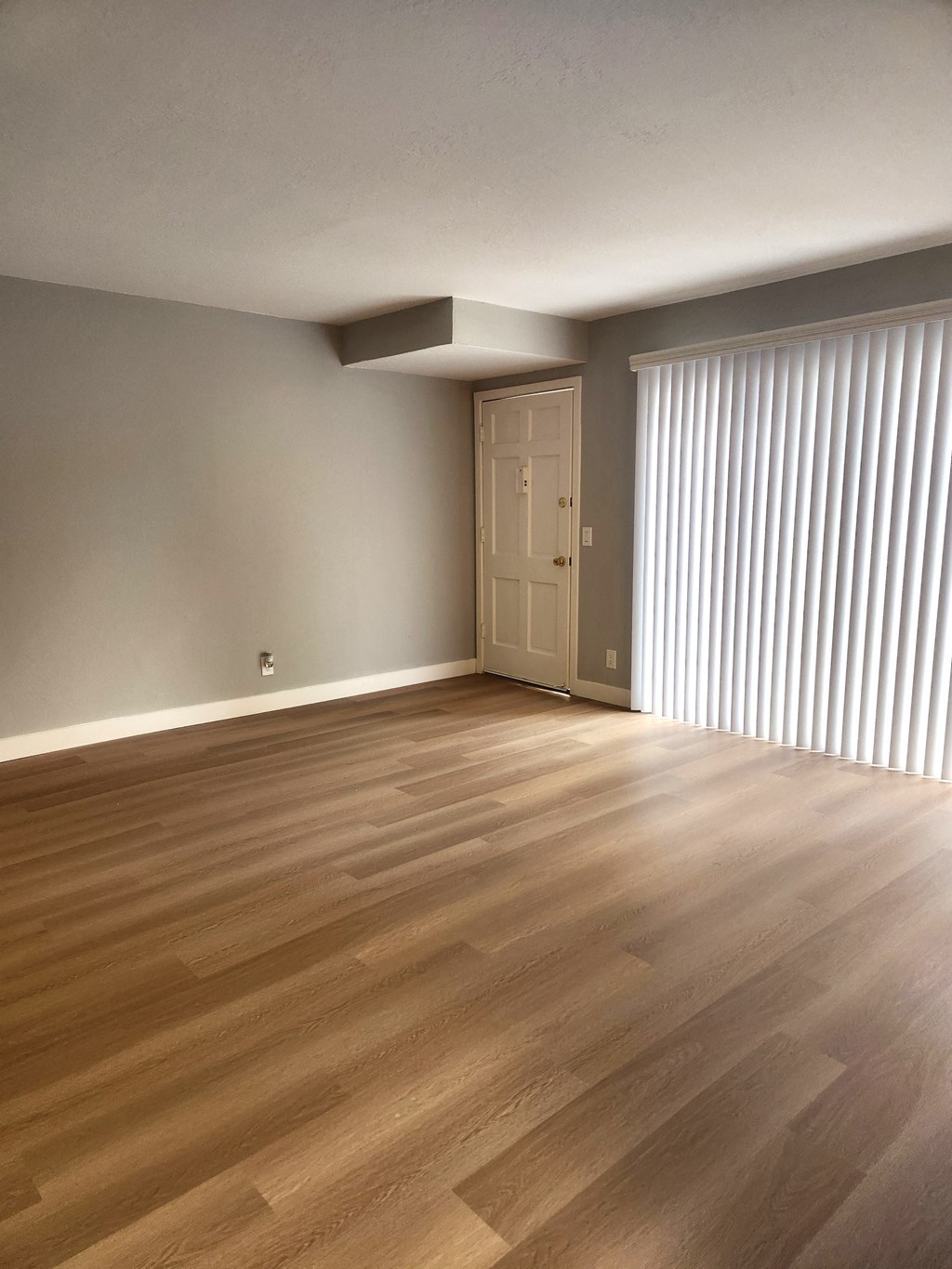 the living room and dining room of an apartment with wood flooring