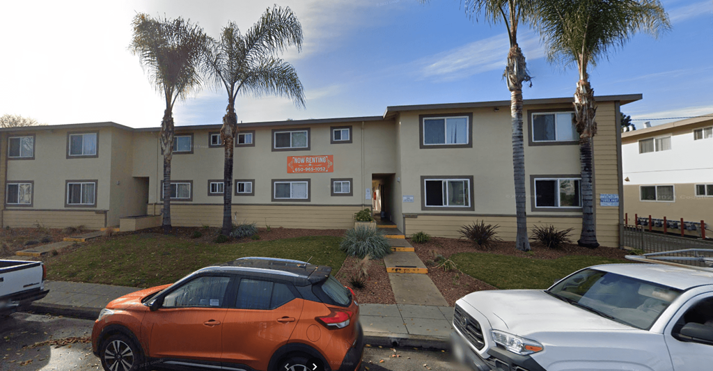 an office building with cars parked in front of it