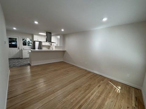 A room with wooden flooring and white walls.