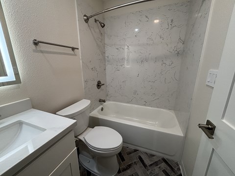 A white toilet sits next to a white sink in a bathroom.