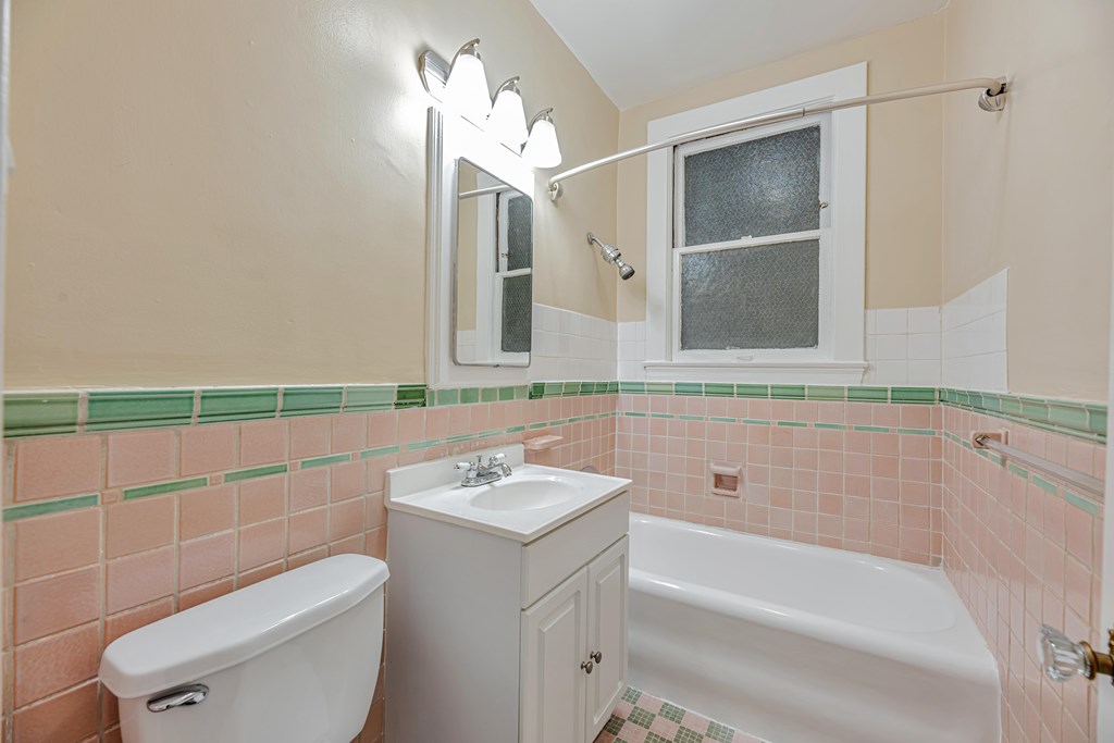 A white toilet sits next to a white sink in a bathroom.