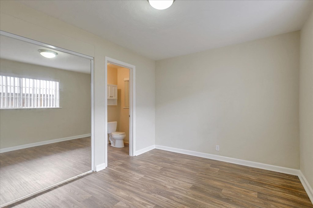 a living room with a mirror and a door to a bathroom