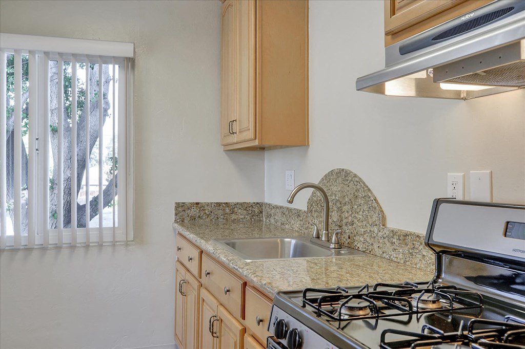 a kitchen with a sink and stove and a window