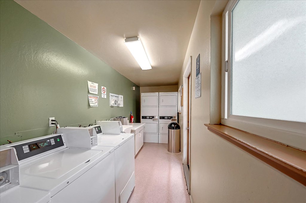 A laundromat with washers and dryers is shown.