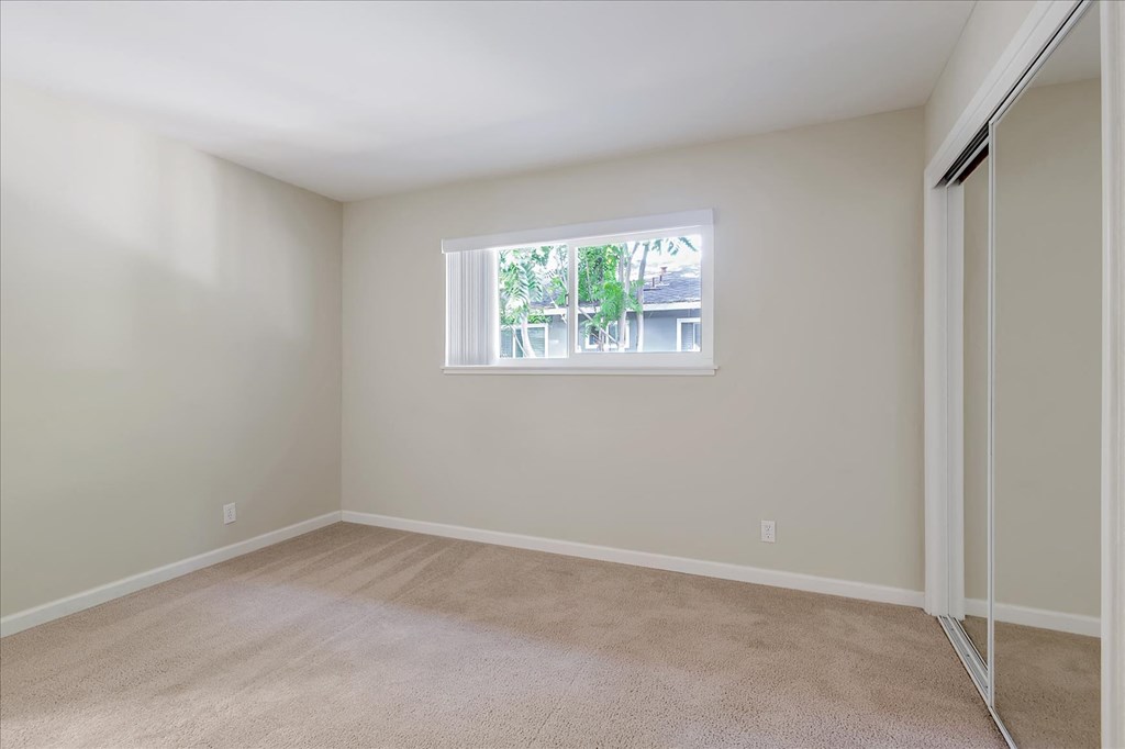 an empty room with a window and a closet