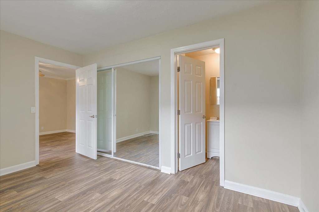 a bedroom with a door open to a hallway and a living room