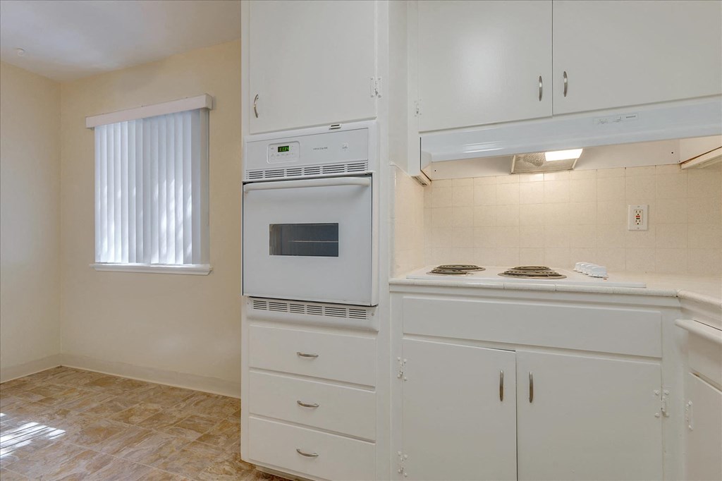 A kitchen with white cabinets and a microwave oven.