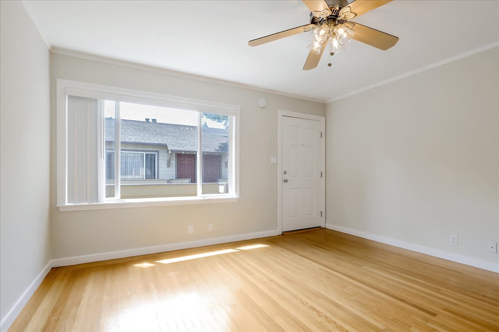 A room with a ceiling fan and a window.