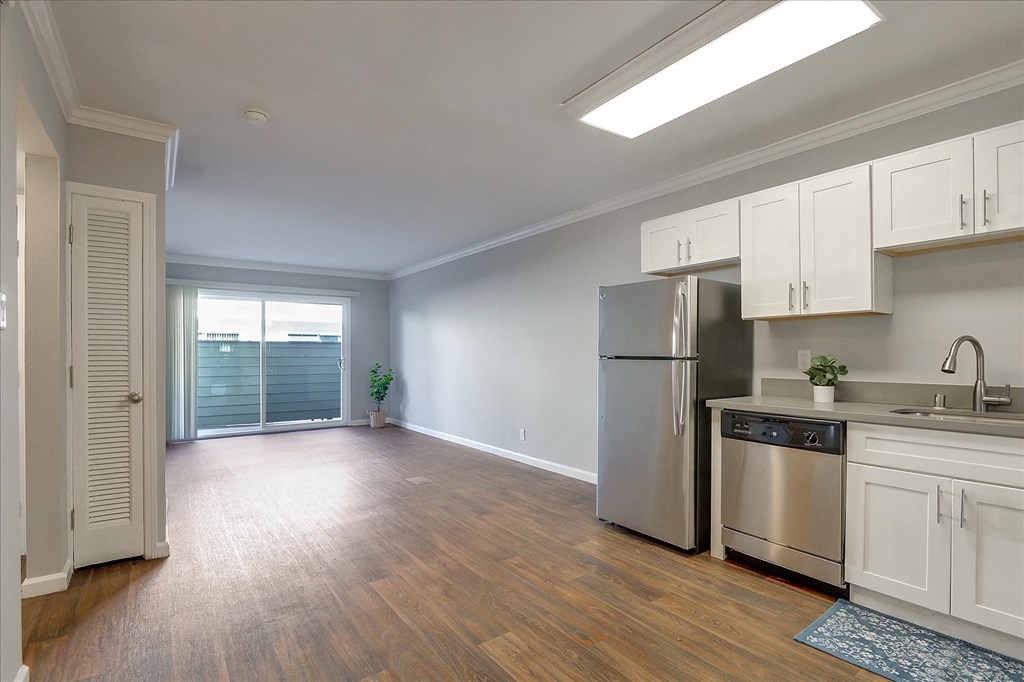 an empty kitchen with stainless steel appliances and white cabinets