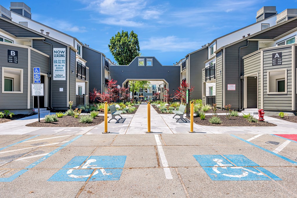 A parking lot with two handicap parking spaces in the foreground.