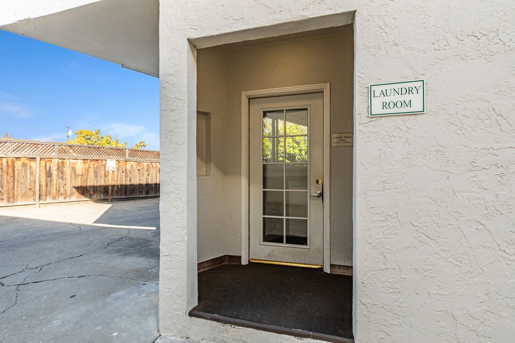 A laundry room sign is on a white wall.