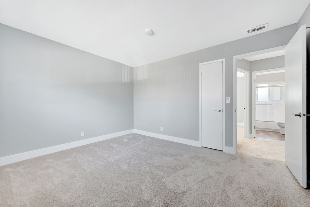 A spacious room with grey walls and carpeted floor.