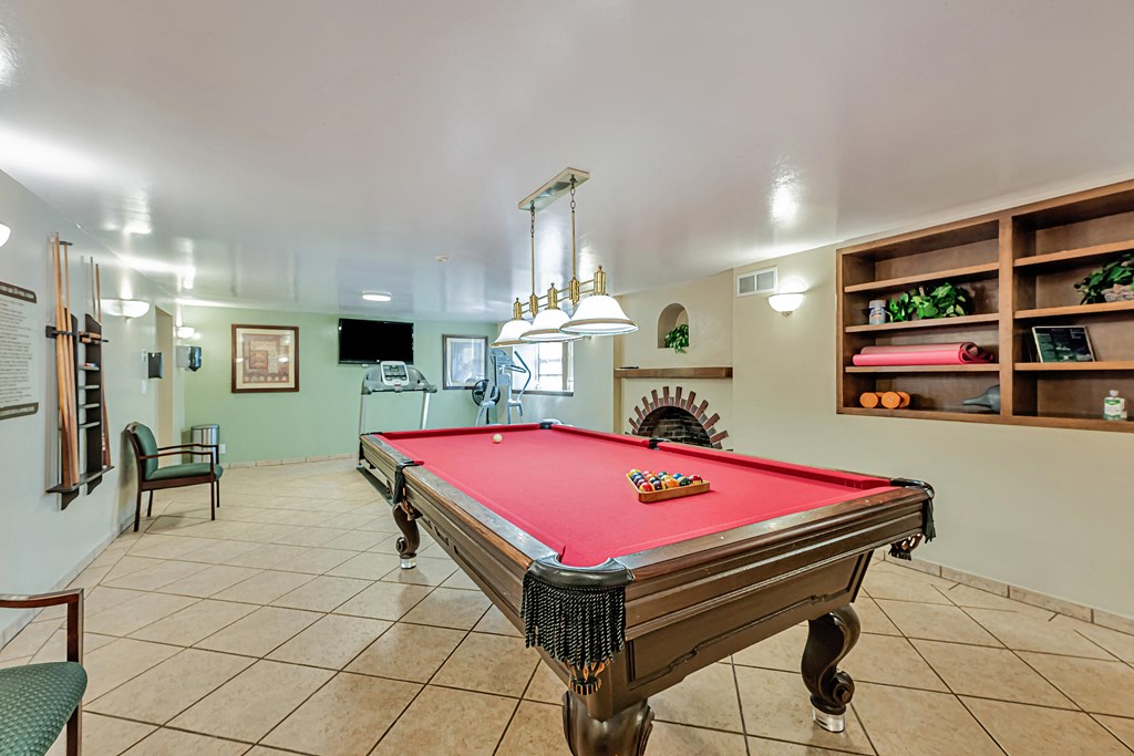 A pool table is in the middle of the room.