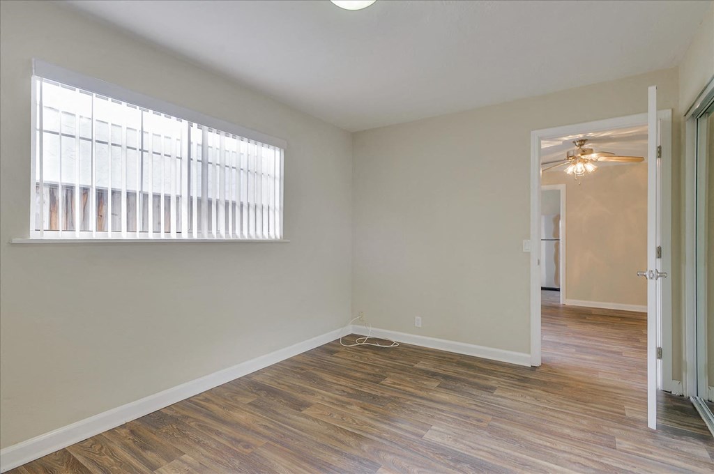 a living room with a large window and a door to a hallway