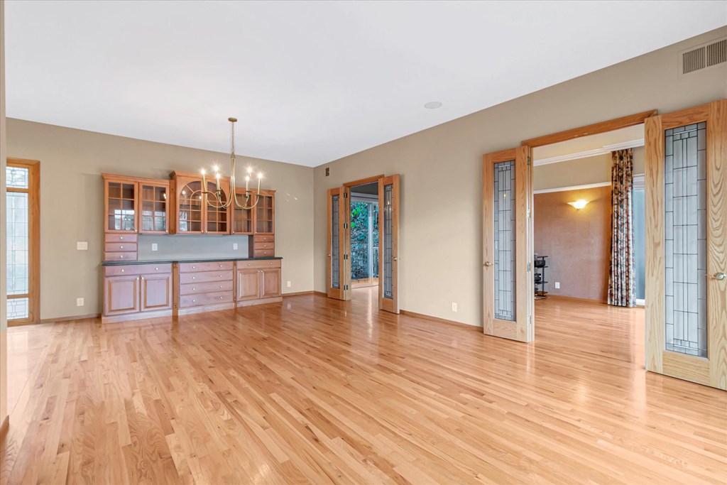 a large living room with a hard wood floor and a kitchen