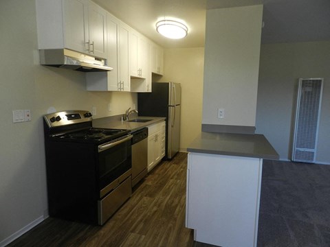 A kitchen with black appliances and white cabinets.