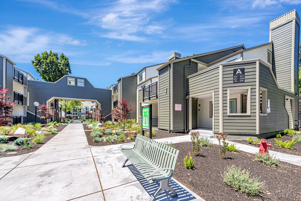 A modern building with a green bench in front of it.