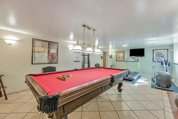 A pool table with a red cloth and a set of pool balls on it.