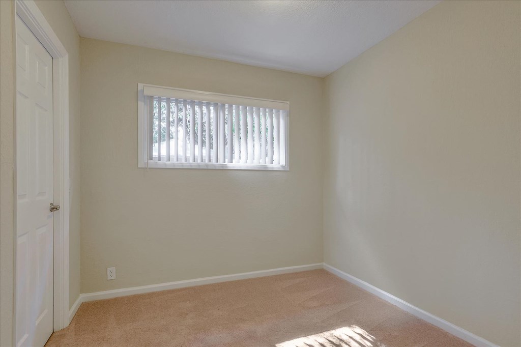 an empty room with a window and a door