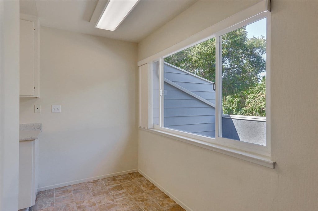 A room with a window and a fireplace.