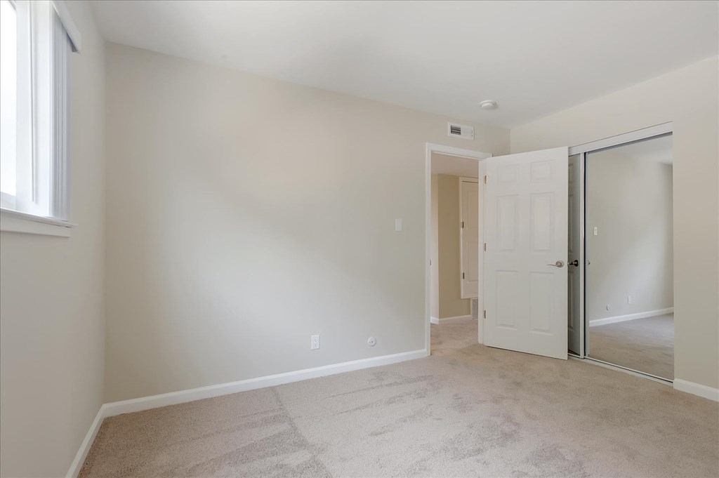 a bedroom with a closet and a door to a hallway