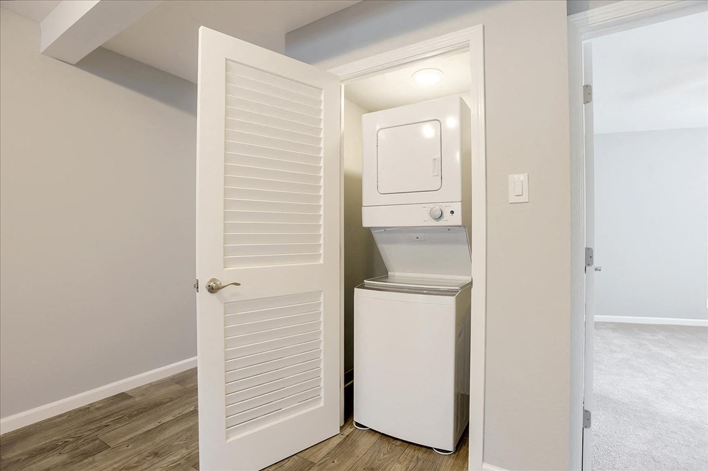 A white refrigerator is in a small room with a door open.