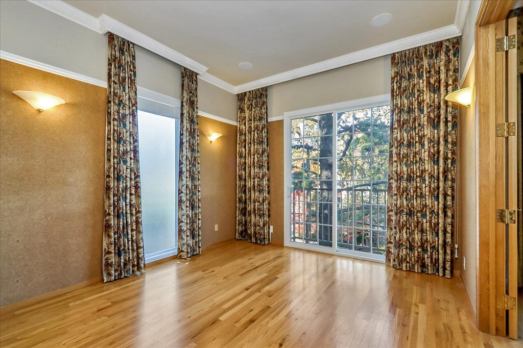 a living room with a large window and wood floors