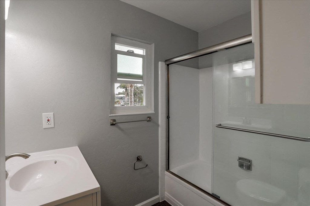 A white sink in a bathroom with a window.