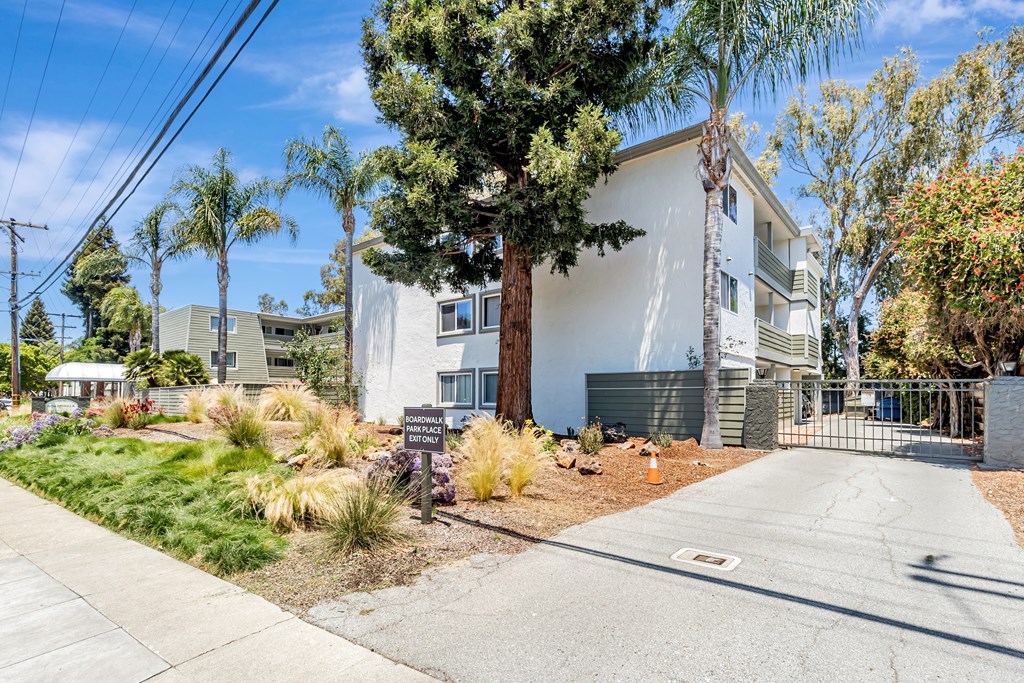 A white building with a tree in front of it.