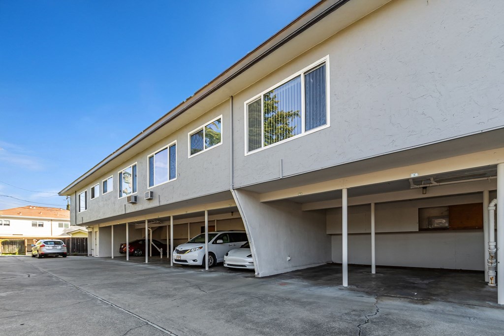 A parking garage with two cars parked inside.