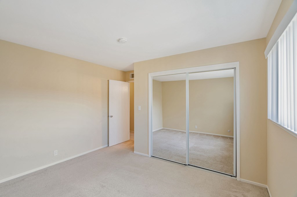 A room with a carpeted floor and a sliding glass door.