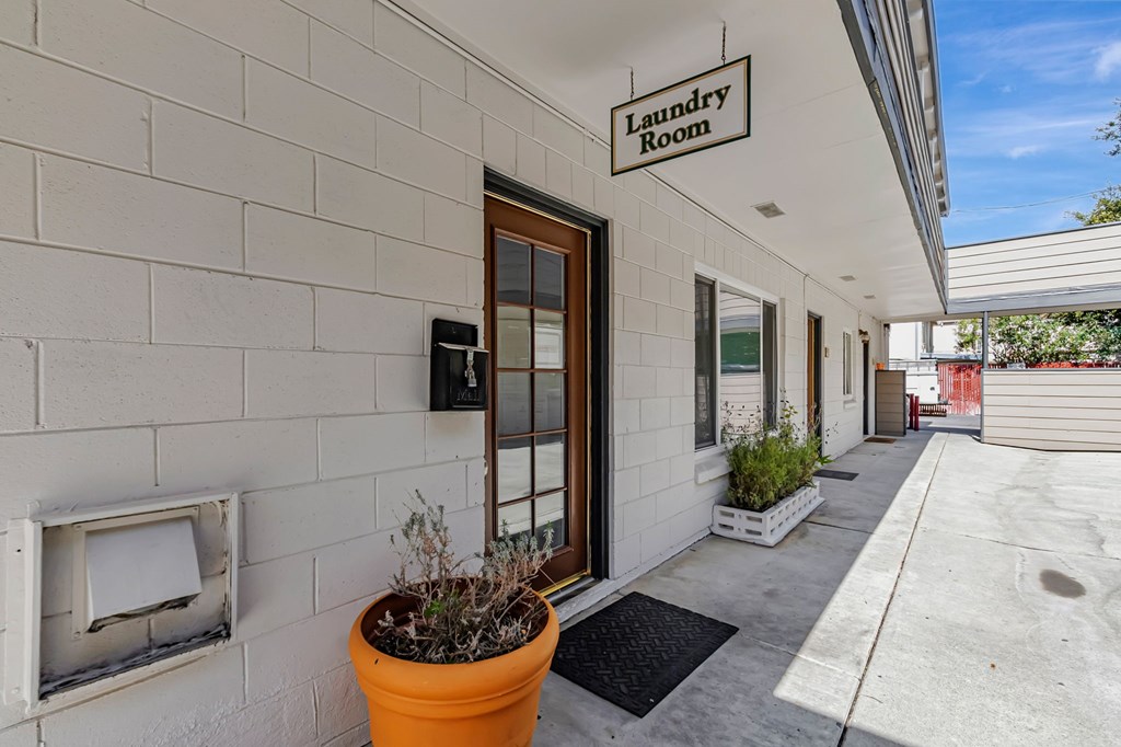 A laundry room sign is hanging on a wall above a door.