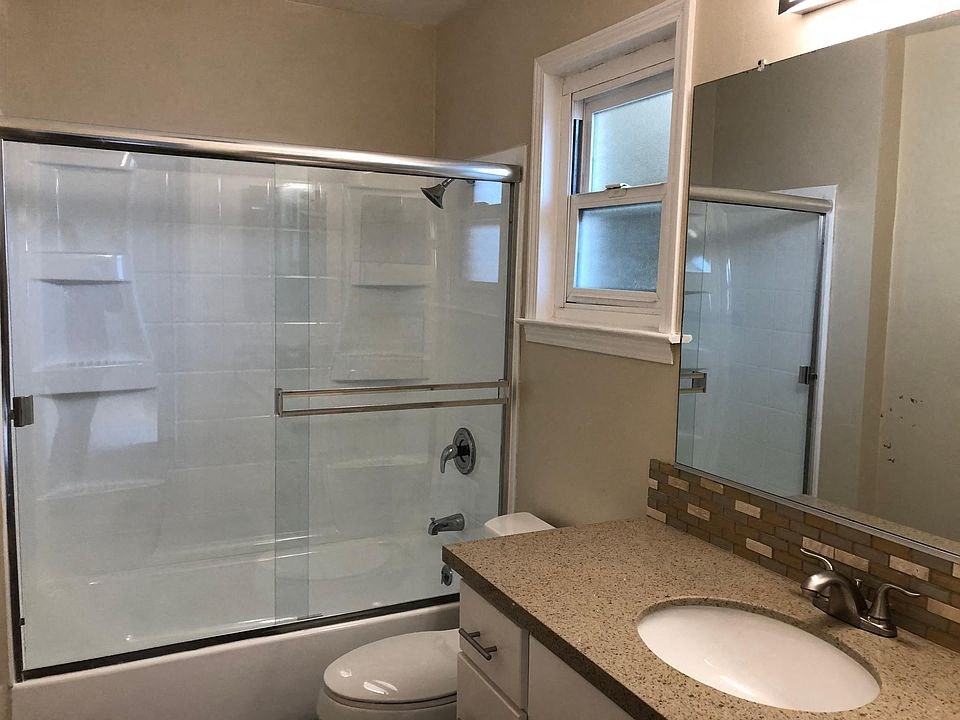 a bathroom with a shower and a sink and a toilet