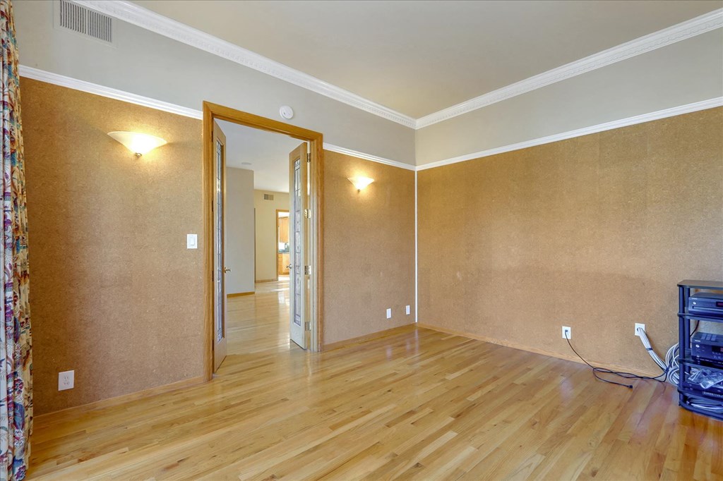 a living room with a hard wood floor and a door to a hallway